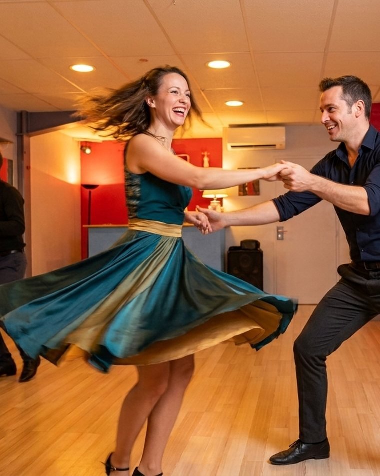 Un couple de danseurs de rock en plein tour dans la salle de cours